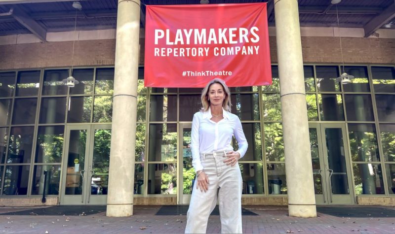 Sharon Lawrence poses in front of a Carolina Playmakers Banner. 